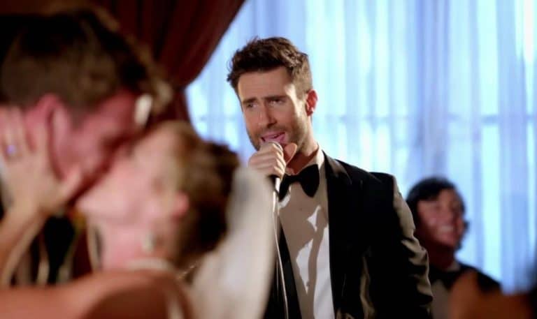 Cantante actuando en una boda mientras los novios se besan, ejemplo de cuánto cobra un cantante por actuar en una boda o fiesta privada