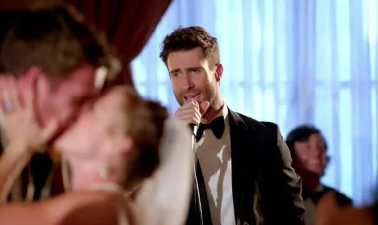 Cantante actuando en una boda mientras los novios se besan, ejemplo de cuánto cobra un cantante por actuar en una boda o fiesta privada